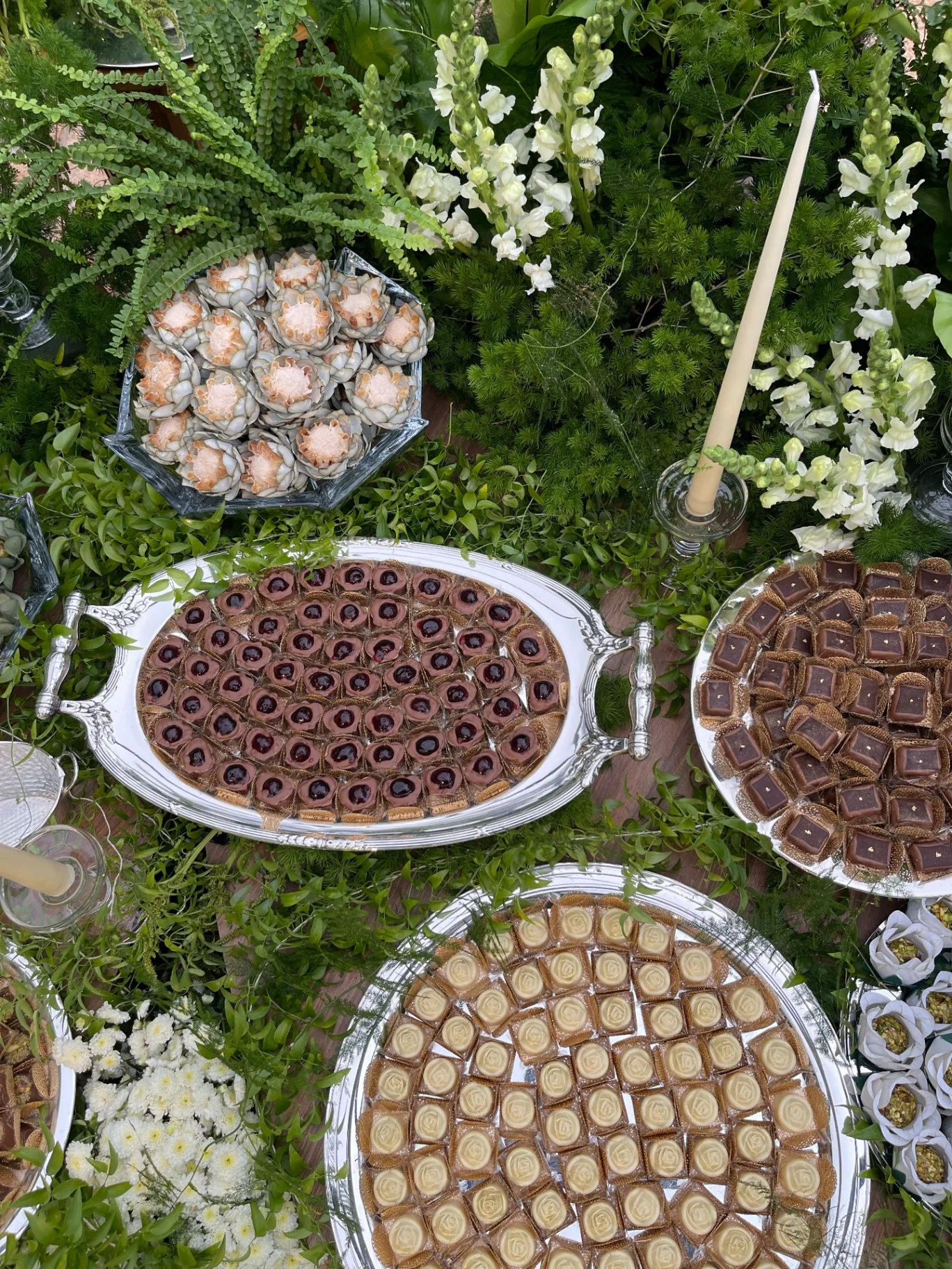 A table of artisanal sweets adorned with white flowers.
