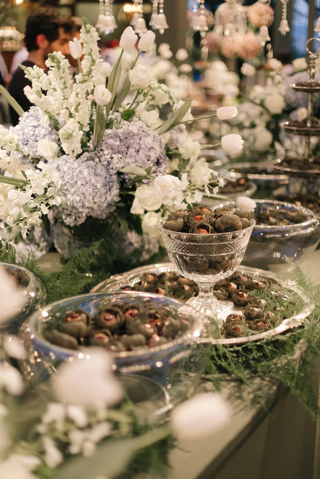 Signature chocolates nestled among arrangements of hydrangeas and white tulips