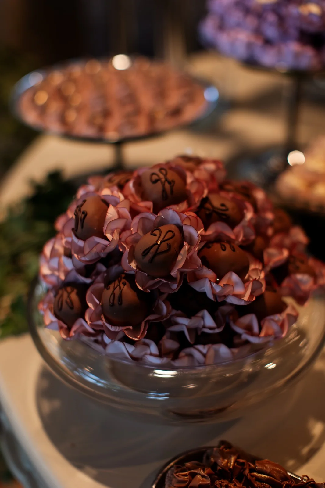 Bonbons in pink wrappers on a glass bowl