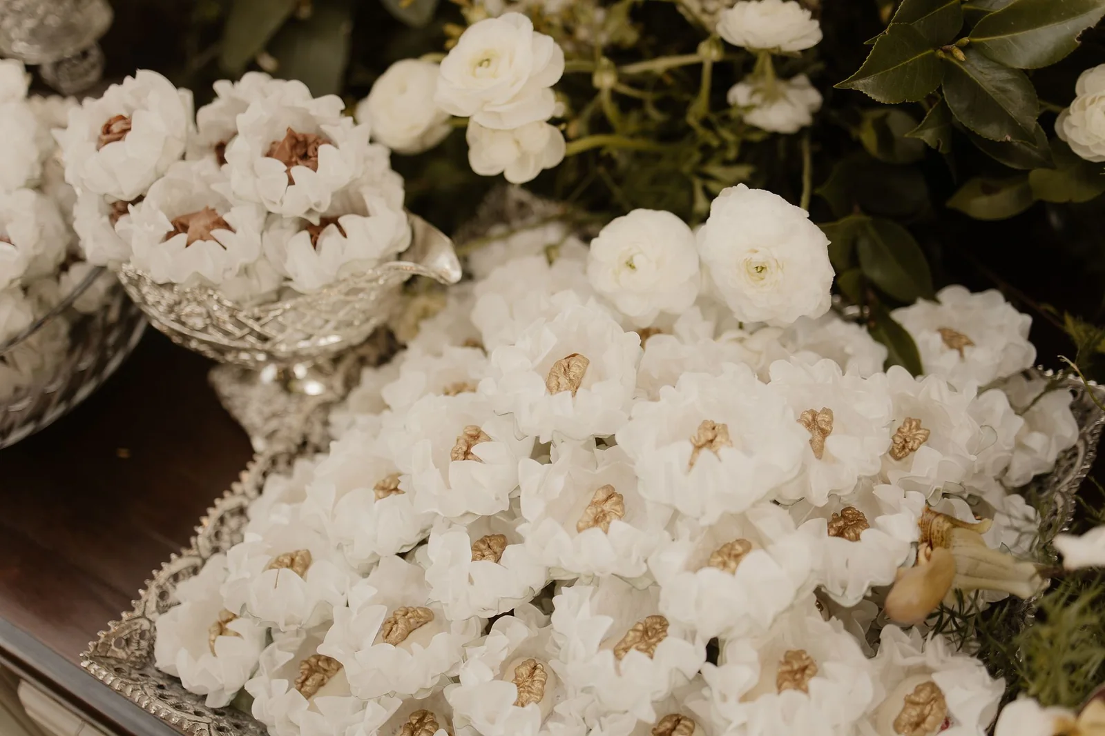 Bonbons in white liners with golden nuts and flowers