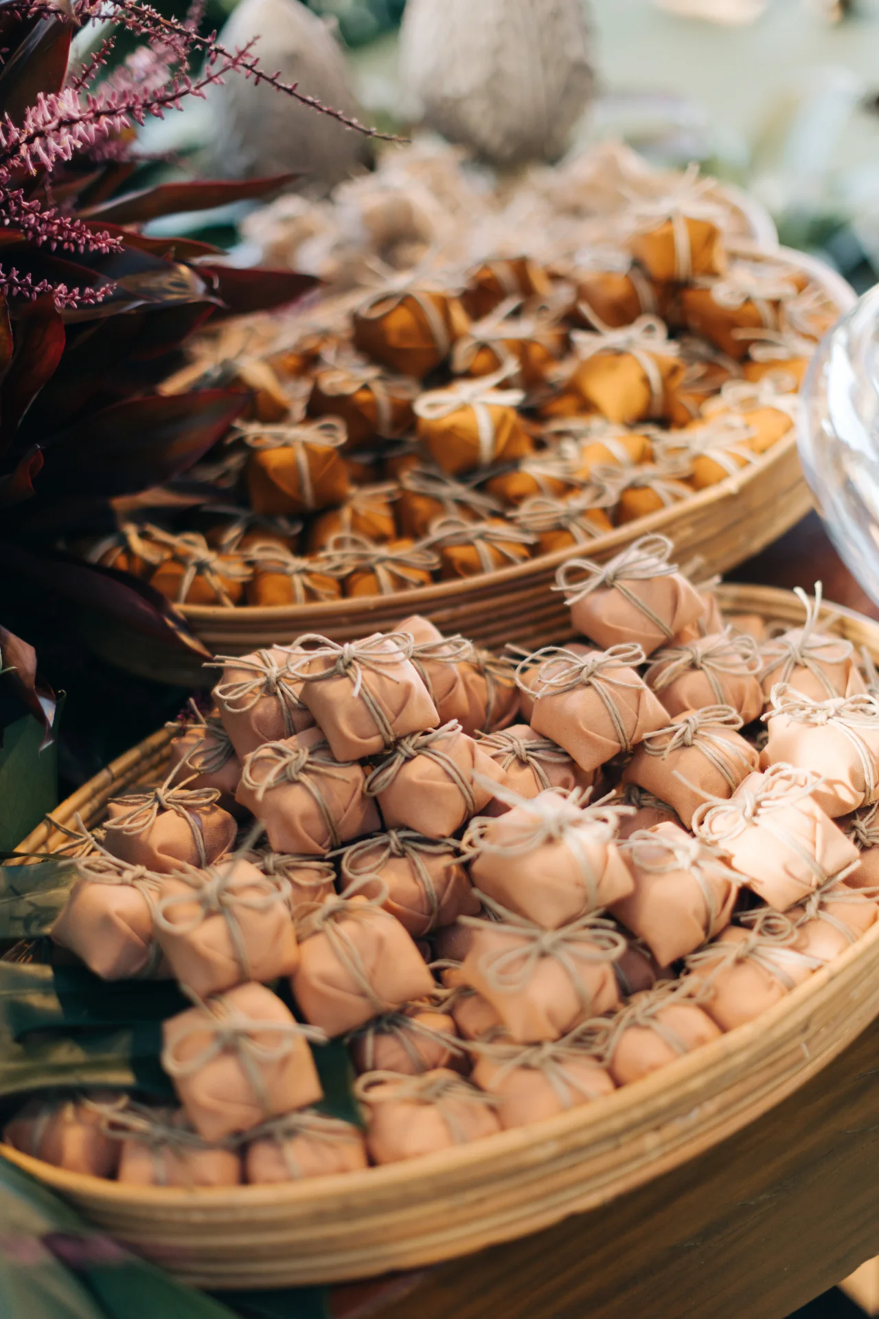 Bem-casados in nude and gold tones arranged in baskets