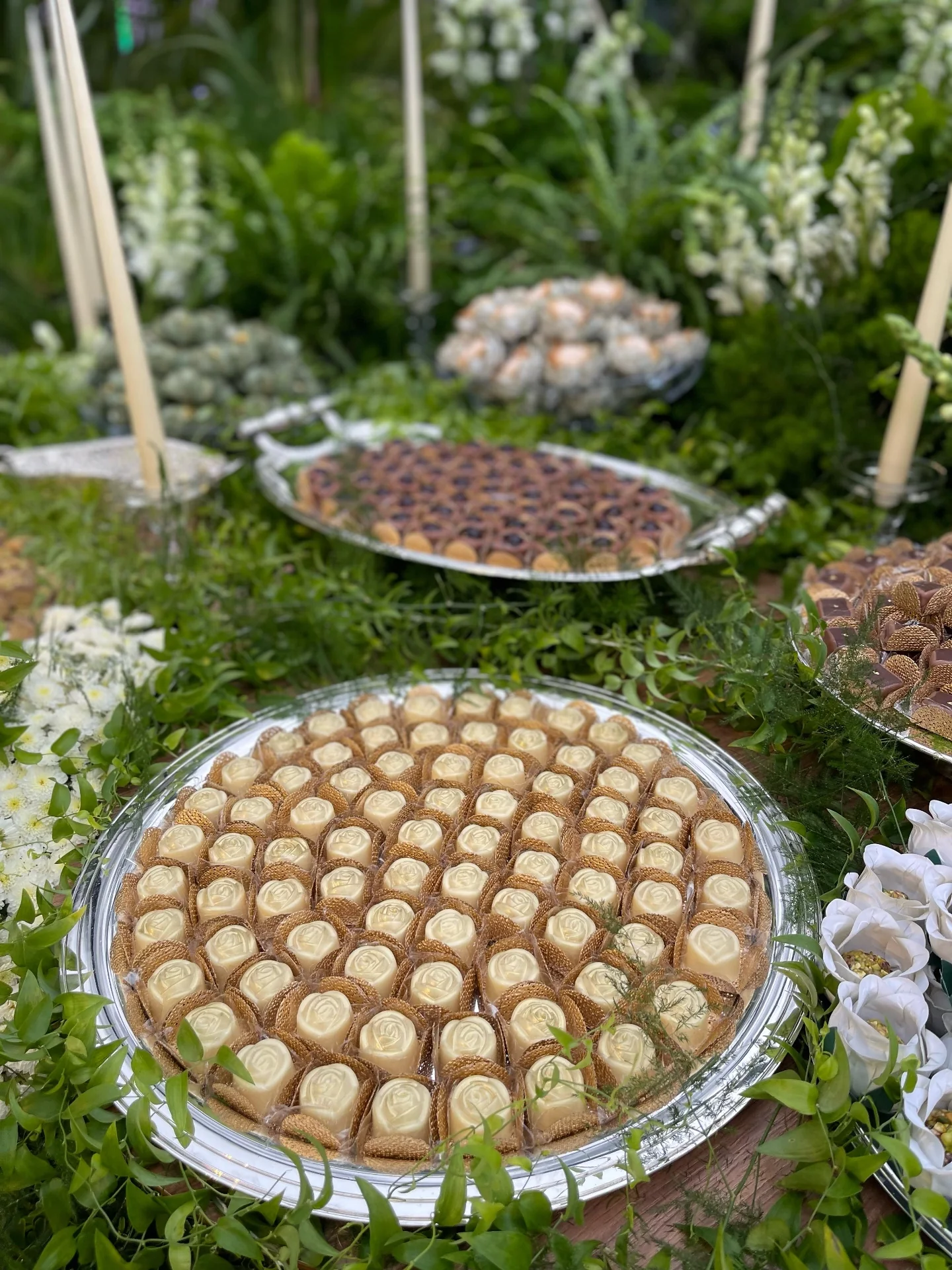 Rose bonbons served on silver, accented with greenery.