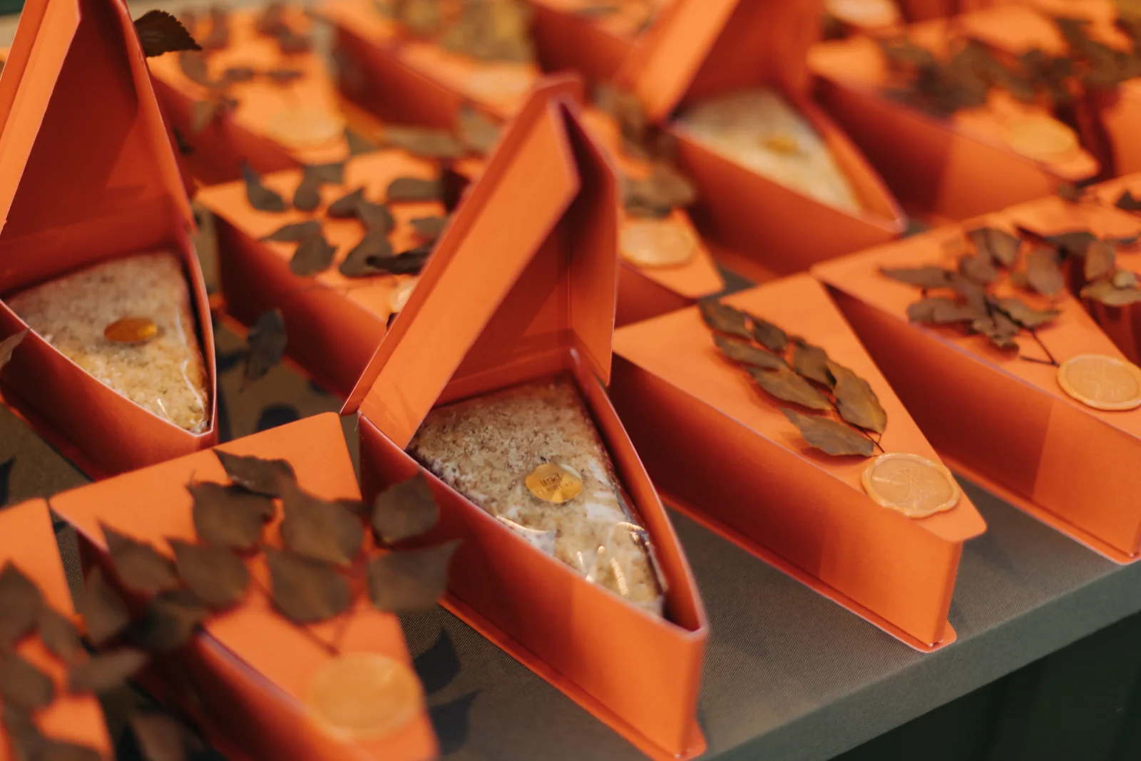 Terracotta boxes with decorated sweets and dried leaves