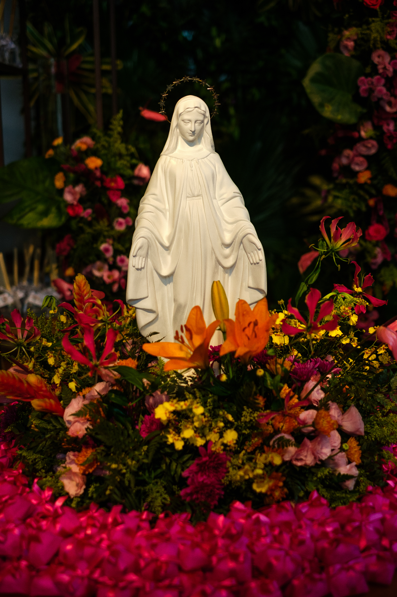 Imagem de Nossa Senhora cercada por flores coloridas